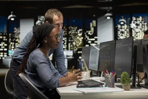 Manager assisting tech startup intern coding with artificial intelligence 写真素材