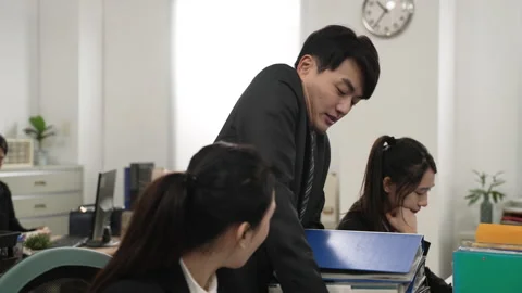 Manager carrying pile of paperwork on worker desk Stock Footage 219428688