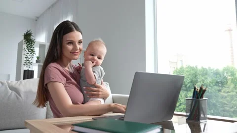 Manager ceo lady sit sofa use netbook maternity leave hold baby indoors Stock Footage 165754213