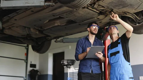 Manager Checks Data on a Notebook and Explains the Breakdown to Mechanic. Car Stock Footage 203721702
