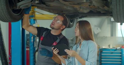 Manager checks data on a tablet computer and explains the breakdown to a Stock Photos