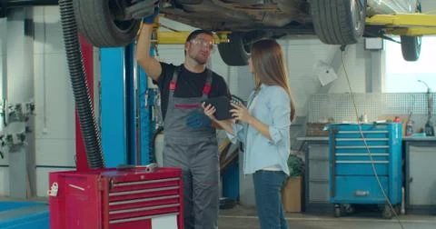 Manager checks data on a tablet computer and explains the breakdown to a Stock Photos