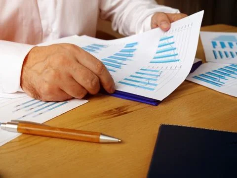The manager is checks a report with graphs about the level of sales. Stock Photos
