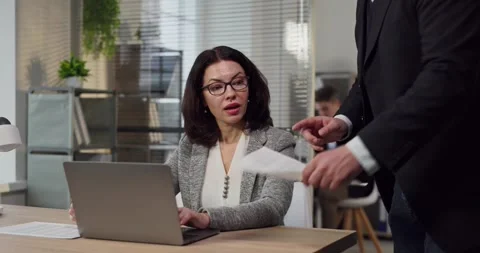 Manager coaching employee during office meeting with laptop and paperwork review Stock Footage 327955675