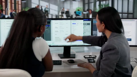 Manager Coaching Young Women Using Document Management System Software Stock Footage 333400982