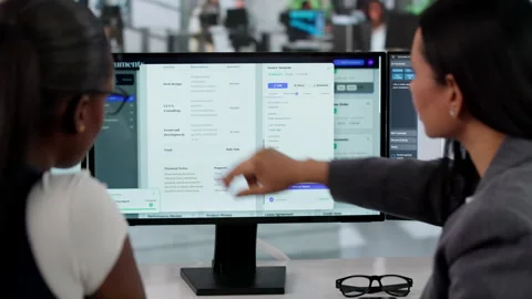 Manager Coaching Young Women Using Document Management System Software Stock Footage 333846228