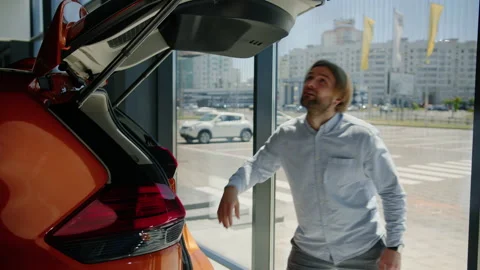 The manager comes to the car and closes the electric trunk Stock Footage 200932745