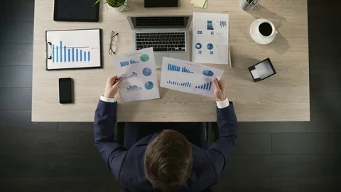 Manager comparing company statistics and entering data on laptop, top view Stock Footage 74366145