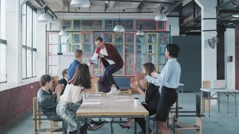 The manager is dancing on the table and singing in a megaphone. His colleague Stock Footage 108369185