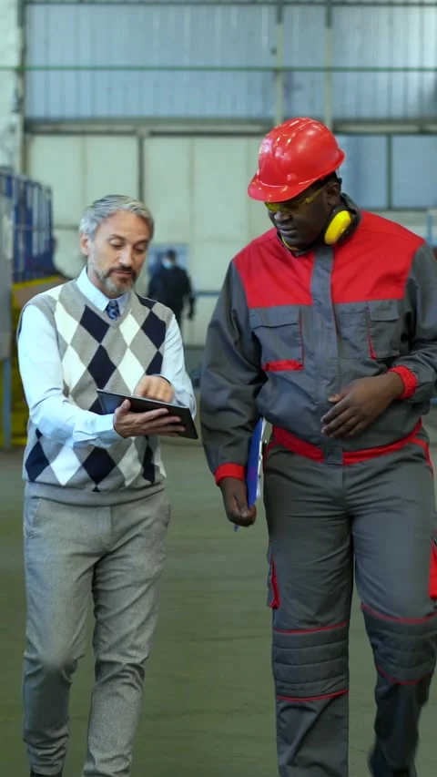 Manager with Digital Tablet and Industrial Worker Discussing in a Factory Stock Footage 312734274
