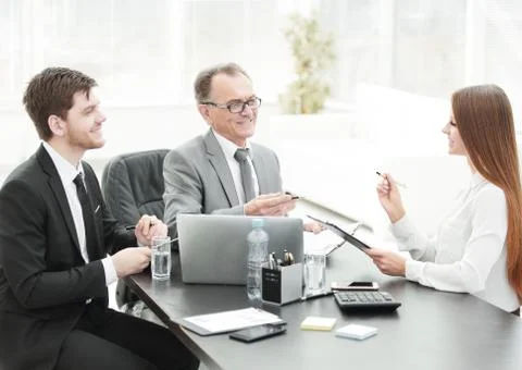 Manager discussing work issues with his assistants behind a Desk Stock Photos