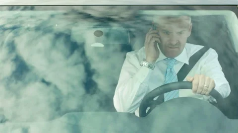 Manager driving car and talking on cell phone Stock Footage 2620257