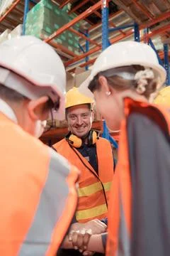 The manager encouraged the warehouse workers to work hard to get the goods... Stock-Fotos