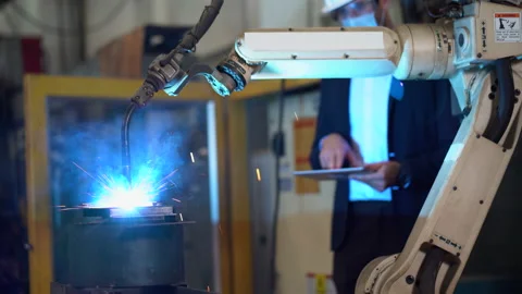 Manager engineer using digital tablet control  Welding robot arms machine in Stock-Footage 154484458