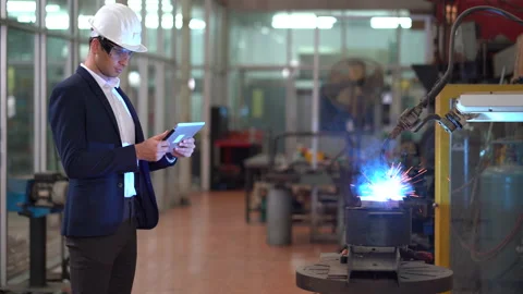 Manager engineer using digital tablet control  Welding robot arms machine in Video stock 154484846