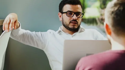 Manager in formal shirt talking with worker and holding his laptop in cafe Stock Footage 112990946