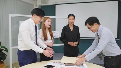 Manager giving gift to group Asian employees for celebrating succes new project. Stock Footage 247553292
