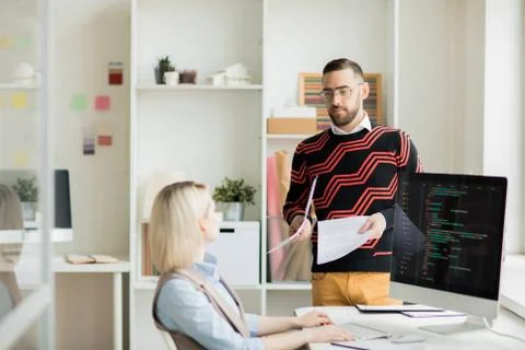 Manager giving paper with task to coding specialist Stock Photos