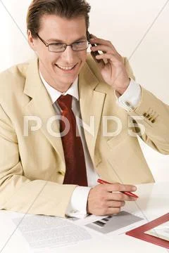 Manager with glasses speaking by his mobile Stock Photos