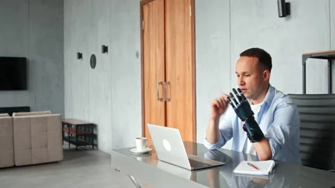 Manager guy with black bio hand prothesis gesticulates Stock Footage 157531918