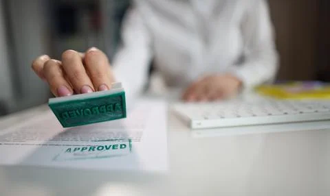Manager hand putting stamp approved on document in office closeup Stock Photos