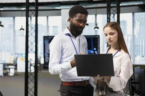 Manager helping young trainee coding during internship in tech startup Stock Photos