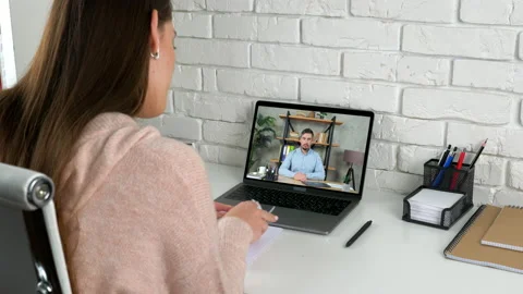 Manager at home search report in notebook tells CEO online video call laptop Stock Footage 156270957