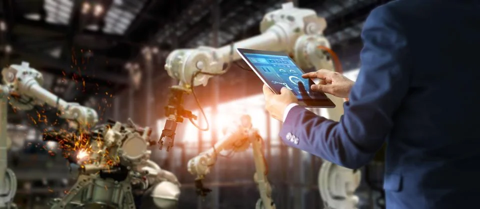 Manager industrial engineer using tablet controlling automation robot Stock Photos