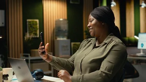 Manager joining remote webinar from office using her smartphone app Stock Photos