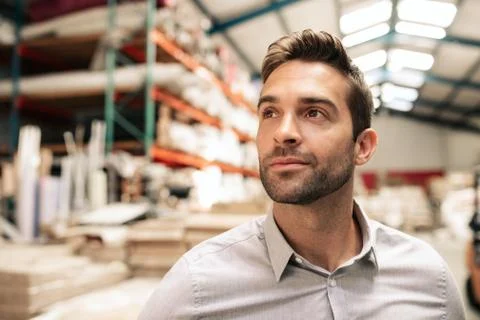 Manager looking at stock while standing in a large warehouse Stock Photos