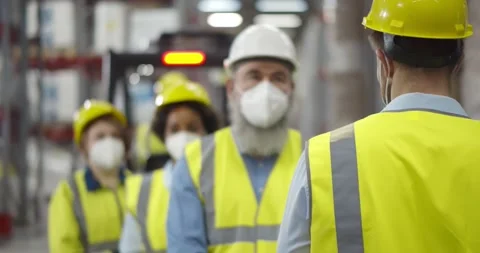 Manager measuring body temperature of warehouse workers with infrared Stock Footage 151397009