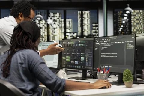 Manager offering feedback to trainee developing machine learning APIs 스톡 사진