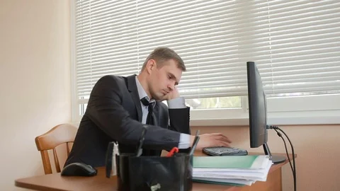 Manager at the office sits at the table tired of work Stock Footage