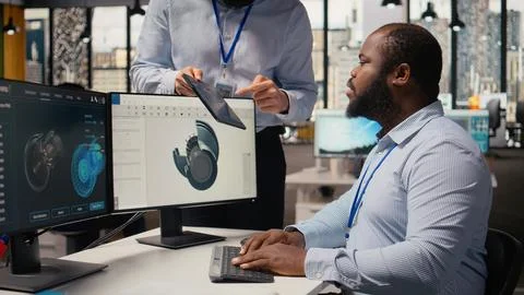 Manager overseeing engineer using CAD app to optimize wind turbine design Stock Photos