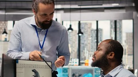 Manager overseeing engineer using CAD app to optimize wind turbine design Stock Photos