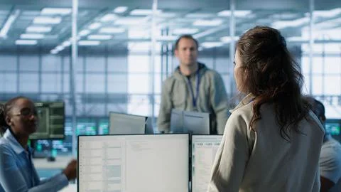 Manager overseeing server room holding impromptu meeting with employees Stock Photos