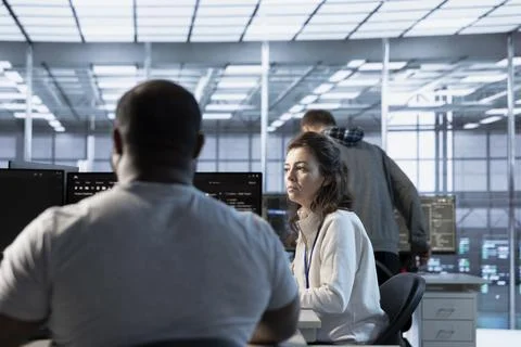 Manager overseeing server room holding impromptu meeting with employees Foto stock