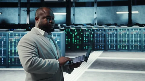 Manager overseeing server room, walking with laptop, troubleshooting hardware Stock Footage 311833330