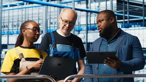 Manager overseeing smart factory, giving instructions to engineers Foto stock