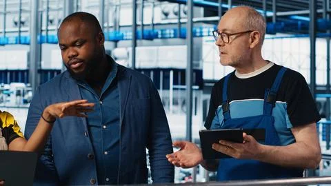 Manager oversees work done by engineering team in industry 4.0 industrial plant Stock Photos