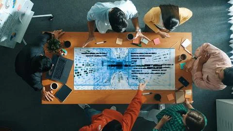 Manager pointing and talking about coding program at meeting room. Convocation. Stock Photos