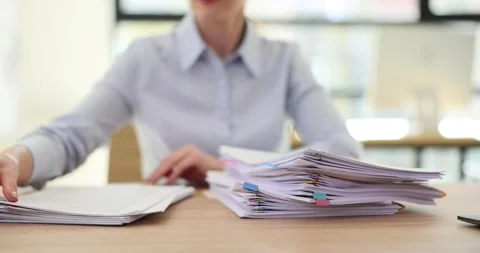 Manager puts business folders with documents in stack on table in office Stock Footage 260593700