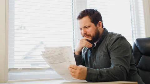 Manager reading documents at cabinet, holding papers and pen. Foto stock
