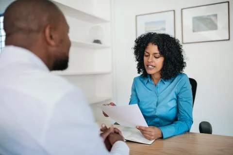 Manager reading a resume during an interview in her office Stock Photos