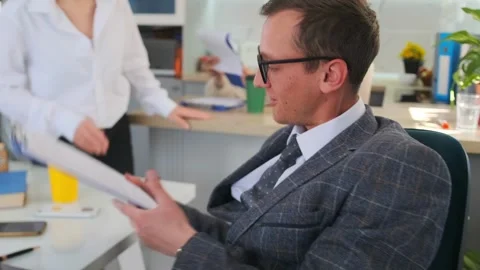 Manager reviews and signs documents leisurely, corporate professional signs Stock Footage 319980005