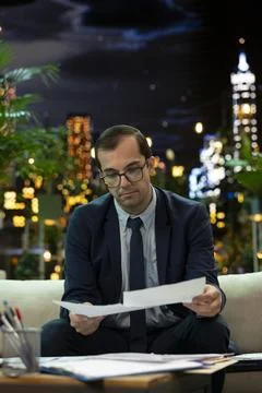 Manager reviews paperwork while seated in outdoor business lounge Stock Photos