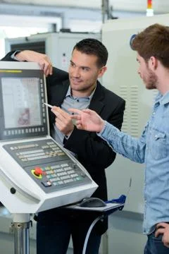 Manager showing apprentice a panel Stock Photos