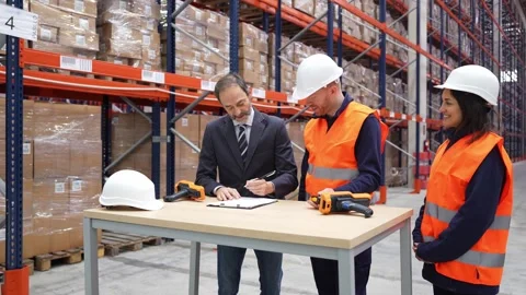 Manager signing contract and shaking hands with workers in warehouse Stock Footage 312856447