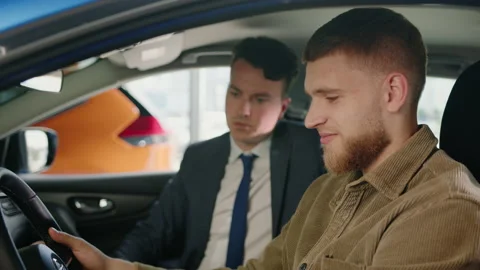 The manager sits in the car with the customers during the test drive Stock Footage 203770119