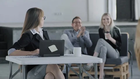 The manager sits at the table and turned to the coveralls who are laughing in Stock Footage 124663707